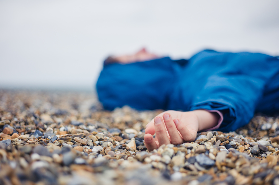 A woman faints on a beach.