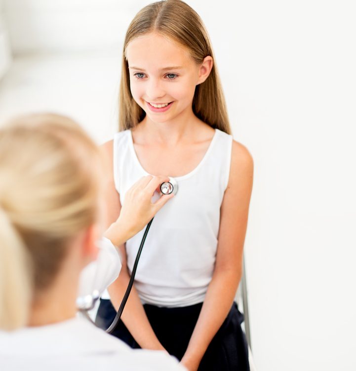 Doctor examines young heart patient with stethoscope.